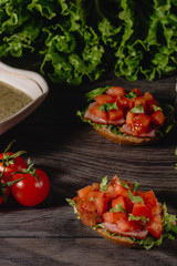 Delicious Italian antipasti bruschetta with chopped tomato, meat pate, sauce, cream cheese and salad leaves. Set of tasty appetizer sandwiches.