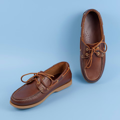 Brown leather men loafers shoes isolated on a blue background. Fashion advertising shoes photos..leather