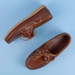 Brown leather men loafers shoes isolated on a blue background. Fashion advertising shoes photos..leather