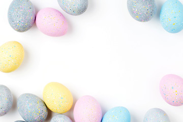 Stylish Frame of pale pink, blue and gray Easter eggs with copy space for text. Flat lay