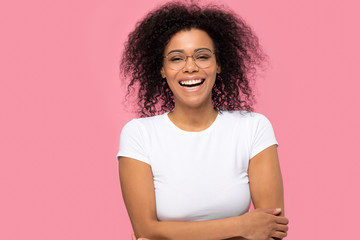 Fototapeta na wymiar Portrait of happy joyful black woman wearing glasses laughing isolated on pink studio background, cheerful funny african american lady with smile on face enjoy laughter having fun looking at camera