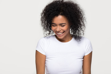 Cheerful black girl laughing at funny joke isolated on white grey blank studio background, happy...