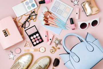 Flat lay of female fashion accessories, makeup products and handbag on pastel color background....