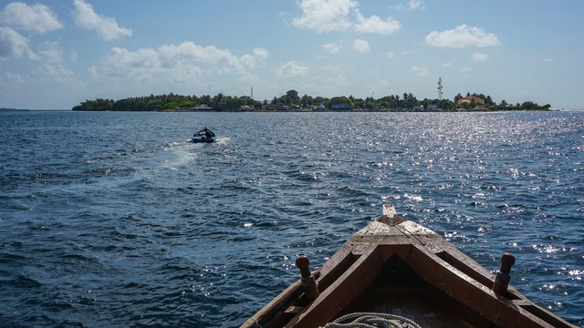 Ein Boot und eine Insel mit Pflanzen und T&uuml;rkis wasser von Adaaran Select Meedhupparu auf Malediven im Indischen Ozean