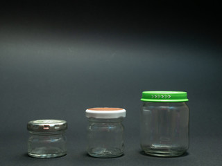tree glass jars for food on black dark background, ascending size