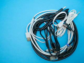 bunch heap of different cables and wires on blue background. flat lay image