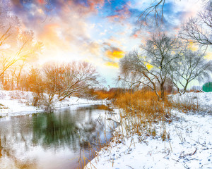Naklejka na ściany i meble Winter landscape by a river in the sunset