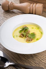 Yellow cream soup served with croutons