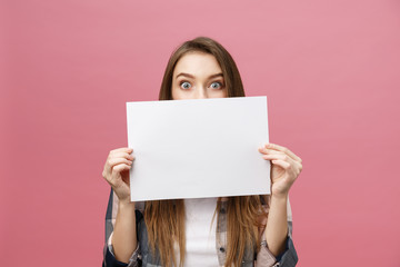 Young caucasian woman holding blank paper sheet over isolated background scared in shock with a surprise face, afraid and excited with fear expression