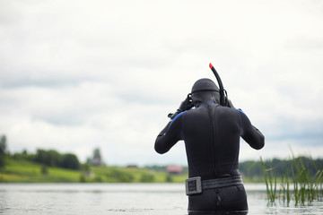A scuba diver in a wet suit prepares