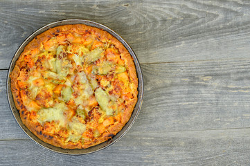Pie with vegetables and cheese in the pan on a vintage grey wood rustic background
