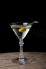 Martini glass with olive on a counter