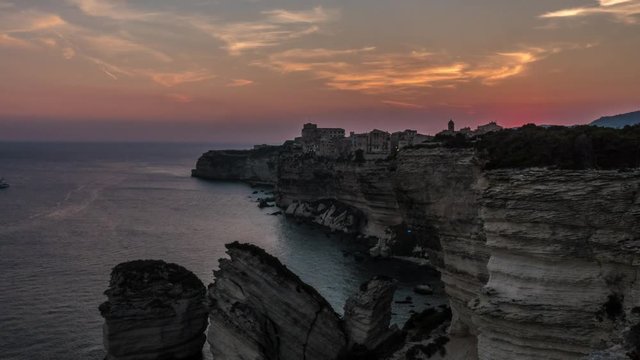 time-lapse of sunset at fortified town on a rock in the sea