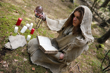 A man in a cassock spends a ritual in a dark forest