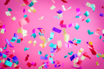 Falling confetti on pink background.