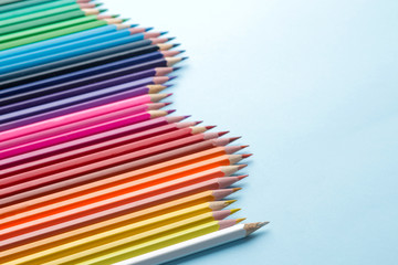 Composition with colored pencils on a bright blue background. close-up. space for text