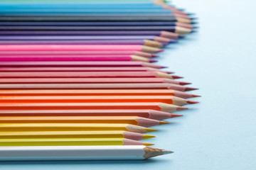 Composition with colored pencils on a bright blue background. close-up. space for text