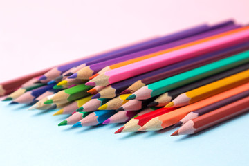 Composition with multicolored pencils on a gentle blue background. close-up.
