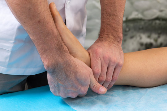 Osteopath therapist makes manipulation and massage to foot the patient.