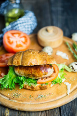 grilled pork sausage sandwich with spices on old wooden background