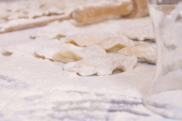 Dumplings with rolling pin on table sprinkled with flour
