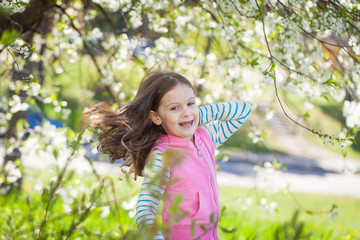 Cute girl in a blooming cherry tree garden