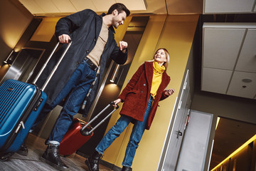 Fototapeta na wymiar Travelling together. Young couple enter to the hotel floor together