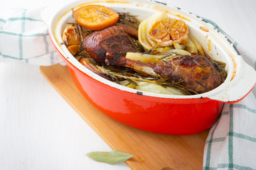 Poultry cooked in a cast iron pan with garlic, orange and aromatic herbs