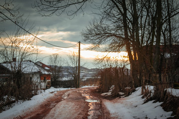 Winter rural scene at sunset with bits of snow