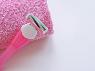 Pink Razor .Removal of unwanted hair. top view. Concept of using razor. Women's Shaving Razor. Shaving razor instrument. Pink shaver in woman hands against pink. beauty, skin care concept .