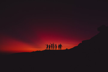 Fototapeta premium Bright sunset and silhouette of happy people