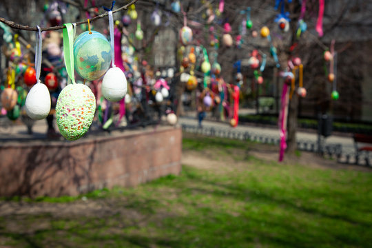 Happy Easter card. Colorful handmade Easter eggs decorated city streets and parks.