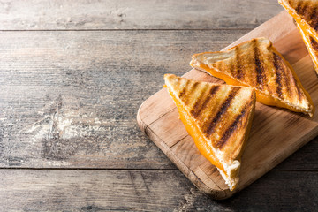 Grilled cheese sandwich on wooden table. Copyspace