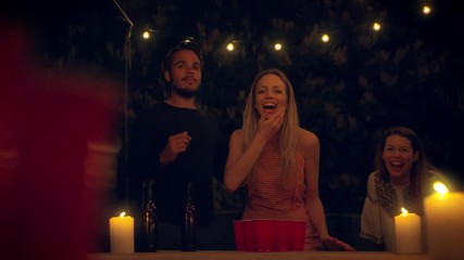 Friends playing beer pong 