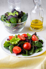 fresh colored cherry tomato salad with arugula, Basil, spinach, salad and olive oil dressing. selective focus.