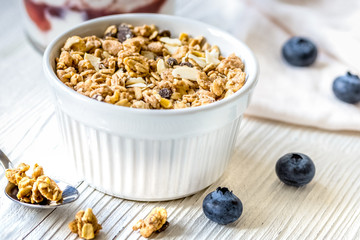 Homemade fitness granola with yoghurt and berries on white kitchen background