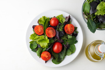 fresh colored cherry tomato salad with arugula, Basil, spinach, salad and olive oil dressing. selective focus.