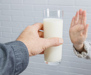 hand rejecting the glass of milk, intolerance to dairy