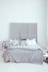 Bedroom interior with light gray bed and white walls