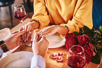 Romantic moments. Young man holding hands of his girlfriend in restaurant