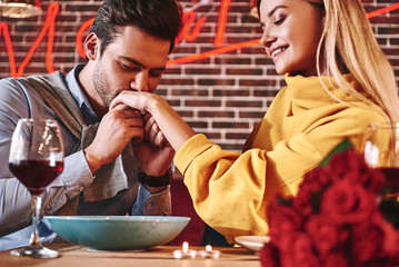Couple love story - Handsome man kisses young womans hand with passion