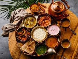 Indian food Thali  Indian-style meal with chicken meat and Masala tea Chai on wooden table