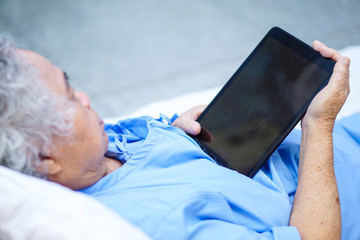 Asian senior or elderly old lady woman patient use tablet.
