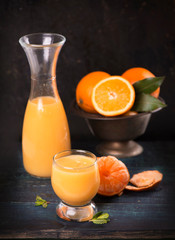 glass of fresh orange juice with fresh fruits on wooden