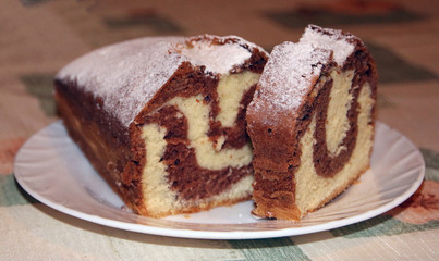 Homemade chocolate cake on a plate, marble texture, close-up view