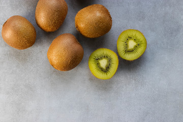 Ripe whole kiwi on a gray background.