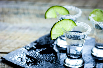 Party in bar with tequila, salt and lime on wooden table