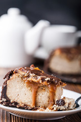 Close up view of a piece of peanut butter chocolate caramel cheesecake pie and cup of coffee on...