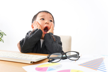 スーツを着て仕事をする子供ビジネスマン