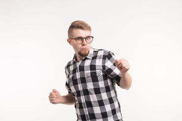People and emotions concept - Handsome young man in plaid shirt dancing funny over white background